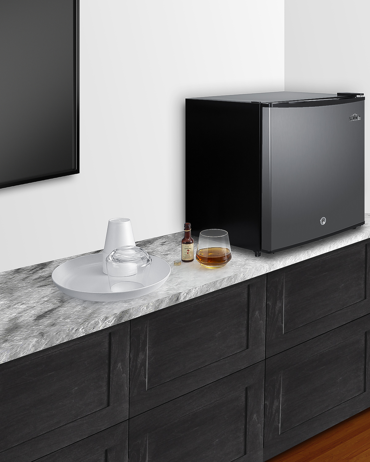 Compact minibar with reversible stainless steel door, front lock, and black cabinet